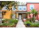 Charming multi-colored townhome with a well-maintained lawn, blooming flowers and lush landscaping at 8487 Crystal Cove Loop, Kissimmee, FL 34747