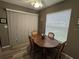 A dining area features a wood table, four chairs, a window, and sliding blind at 1001 Plantation Dr # A2, Kissimmee, FL 34741