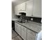 Kitchen with granite countertops, stainless steel sink, black subway tile backsplash, and white cabinets at 1001 Plantation Dr # A2, Kissimmee, FL 34741