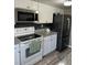 Updated kitchen with white cabinets, granite countertops, stainless steel appliances, and wood-style floors at 1001 Plantation Dr # A2, Kissimmee, FL 34741