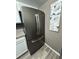 Close-up of a stainless steel, french-door refrigerator against a neutral wall with art in an updated kitchen at 1001 Plantation Dr # A2, Kissimmee, FL 34741
