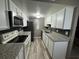 Kitchen featuring white cabinets, stainless steel appliances, granite countertops, and modern backsplash at 1001 Plantation Dr # A2, Kissimmee, FL 34741