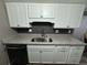 Kitchen with granite countertops, stainless steel sink, black backsplash, and white cabinets at 1001 Plantation Dr # A2, Kissimmee, FL 34741