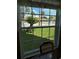 A dining room's window view shows a lush green lawn, palm trees, and an in-ground pool at 1001 Plantation Dr # A2, Kissimmee, FL 34741
