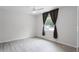 Bright bedroom with light wood-look floors, ceiling fan, and window with dark curtains at 10105 Crozier Ct, Orlando, FL 32817