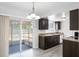 Bright eat-in kitchen with dark wood cabinets, granite countertops, and access to a screened-in patio at 10105 Crozier Ct, Orlando, FL 32817