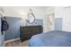 Stylish bedroom featuring a dresser, modern decor, and a calming blue and white color scheme at 10132 Huntingnet Way, Leesburg, FL 34748