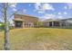 View of the backyard featuring lush green grass, a screened-in lanai, and a well-maintained fence at 1028 Sadie Ridge Rd, Clermont, FL 34715