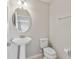 Bright half-bathroom features a pedestal sink, oval mirror and neutral tones at 1028 Sadie Ridge Rd, Clermont, FL 34715