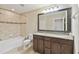Bathroom featuring a double vanity, large mirror, bathtub and tiled shower at 1028 Sadie Ridge Rd, Clermont, FL 34715