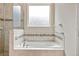 Soaking tub with tile surround and glass walk-in shower in a bright bathroom at 1028 Sadie Ridge Rd, Clermont, FL 34715