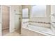 Large soaking tub with glass walk-in shower in a bright bathroom next to the walk-in closet at 1028 Sadie Ridge Rd, Clermont, FL 34715