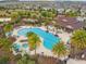 Aerial view of the community pool area featuring lounge chairs, a hot tub, and palm trees at 1028 Sadie Ridge Rd, Clermont, FL 34715