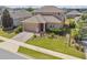 Inviting home showcasing lush landscaping, a brick driveway, and a two-car garage at 1028 Sadie Ridge Rd, Clermont, FL 34715