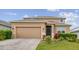 Charming two-story home featuring a well-manicured lawn, brick driveway, and attached two-car garage at 1028 Sadie Ridge Rd, Clermont, FL 34715
