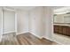 Hallway with wood flooring leading to a bathroom with double vanity at 1028 Sadie Ridge Rd, Clermont, FL 34715