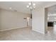 Open-concept living room with neutral paint, tile floors, chandelier, and doorway to kitchen at 1028 Sadie Ridge Rd, Clermont, FL 34715