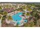 Aerial view showcasing a stunning resort-style pool with palm trees, lounge chairs, and a spacious pool deck at 1028 Sadie Ridge Rd, Clermont, FL 34715