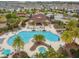 Aerial view of a beautiful resort-style pool with palm trees and lounge chairs, perfect for relaxation and recreation at 1028 Sadie Ridge Rd, Clermont, FL 34715