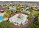 Aerial view of a community splash pad with palm trees, chairs, and tables at 1028 Sadie Ridge Rd, Clermont, FL 34715