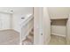 Hallway view of carpeted stairway, half-bath closet and front door with tile flooring at 1028 Sadie Ridge Rd, Clermont, FL 34715