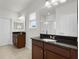 This bathroom features dual sinks, granite counters, tile floors, and white doors at 1052 Avila Ln, Orlando, FL 32803