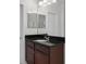 This bathroom boasts a sink with granite counters, a large mirror, and white door at 1052 Avila Ln, Orlando, FL 32803