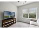 Well-lit bedroom featuring a window, comfortable couch, and a TV perfect for relaxation at 1052 Avila Ln, Orlando, FL 32803