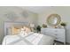 Bright bedroom featuring stylish decor, a comfortable bed, and a decorative accent mirror above a white dresser at 1078 Clay Blvd, Tavares, FL 32778