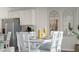 Bright dining area featuring a white table set for six, adjacent to the kitchen with stainless steel appliances at 1078 Clay Blvd, Tavares, FL 32778