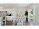 Contemporary dining area with a white table, chairs, mirrors, and a view of the outdoor scenery at 1078 Clay Blvd, Tavares, FL 32778