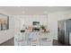 Modern kitchen features a breakfast bar with white chairs and stainless steel appliances for a contemporary style at 1078 Clay Blvd, Tavares, FL 32778