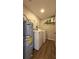 Functional laundry room features a washer, dryer, water heater, and shelving for storage at 111 Palencia Rd, Auburndale, FL 33823