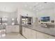 Open concept kitchen with white cabinetry, stainless appliances, and connecting dining and living spaces at 11400 Lovers Ln, Winter Garden, FL 34787