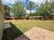 Wide angle of the large backyard with privacy fence, wooden swing set and brick patio at 12101 Kendra Ct, Orlando, FL 32824