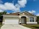 Charming single-story home with a well-maintained lawn and a two-car garage at 12101 Kendra Ct, Orlando, FL 32824