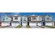 Modern townhome featuring a one-car garage and beautiful color accents against a sunny, blue sky backdrop at 1255 Stockwell Ave, St Cloud, FL 34771
