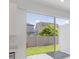 Backyard view from kitchen features sliding glass door and brick-paved patio at 1263 Stockwell Ave, St Cloud, FL 34771
