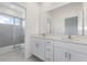Bright bathroom featuring a double vanity, white cabinets, and a glass enclosed shower at 1263 Stockwell Ave, St Cloud, FL 34771
