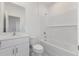 A bright bathroom with a white vanity, toilet, and tub with white subway tile at 1263 Stockwell Ave, St Cloud, FL 34771