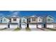 Charming townhome showcases a modern facade, two-car garage, and manicured front lawn at 1263 Stockwell Ave, St Cloud, FL 34771