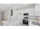 Bright, modern kitchen featuring stainless steel appliances, white cabinets, and stone countertops at 1263 Stockwell Ave, St Cloud, FL 34771