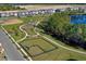 Aerial view of a community park featuring a playground and a fenced dog park, surrounded by ponds and nature at 13540 Autumn Harvest Ave, Winter Garden, FL 34787