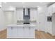 Stylish kitchen with white cabinets, stainless steel hood, and large island perfect for entertaining at 13540 Autumn Harvest Ave, Winter Garden, FL 34787
