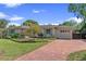 Charming single-story home with brick driveway and lush landscaping, set against a clear blue sky at 1440 Roosevelt St, Orlando, FL 32804
