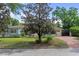 Beautifully landscaped home with a brick driveway and a mature tree in the front yard at 1440 Roosevelt St, Orlando, FL 32804