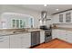 White kitchen with stainless steel appliances, granite countertops, and hardwood floors at 1440 Roosevelt St, Orlando, FL 32804