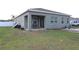 View of the backyard showcasing the home's exterior, a screened in patio, and green space at 146 Loblolly Ln, Davenport, FL 33837