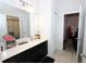 Bathroom with a large mirror, vanity with drawers and cabinets, white tile flooring, and updated lighting at 146 Loblolly Ln, Davenport, FL 33837