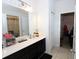 Bathroom with a large mirror, vanity with drawers and cabinets, white tile flooring, and updated lighting at 146 Loblolly Ln, Davenport, FL 33837